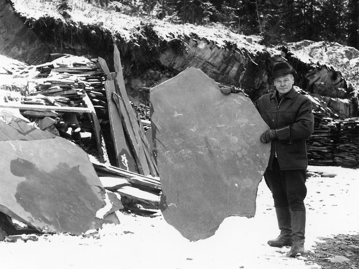 Viinijärven Kiven louhos 1960-luvulla. Rakennusmestari, louhoksen perustaja M.G. Kamppinen esittelee jättikokoista liuskekiveä. Viinijärven Kiven louhos 1960-luvulla. Rakennusmestari, louhoksen perustaja M.G. Kamppinen esittelee jättikokoista liuskekiveä.